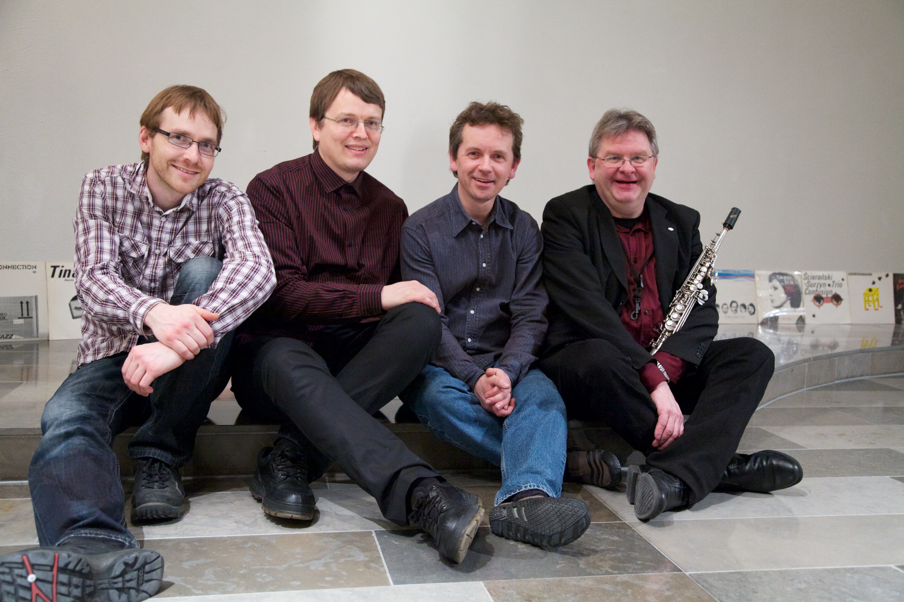 Bandgruppebilde — fire musikere foran albumcover